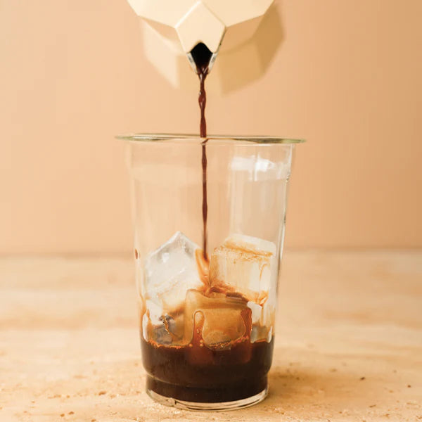 Espresso in ein Glas füllen, Eiswürfel dazu geben.